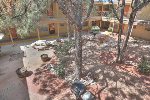 an aerial view of a courtyard with trees and benches